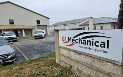 A sign for g 1 mechanical in front of an industrial building.